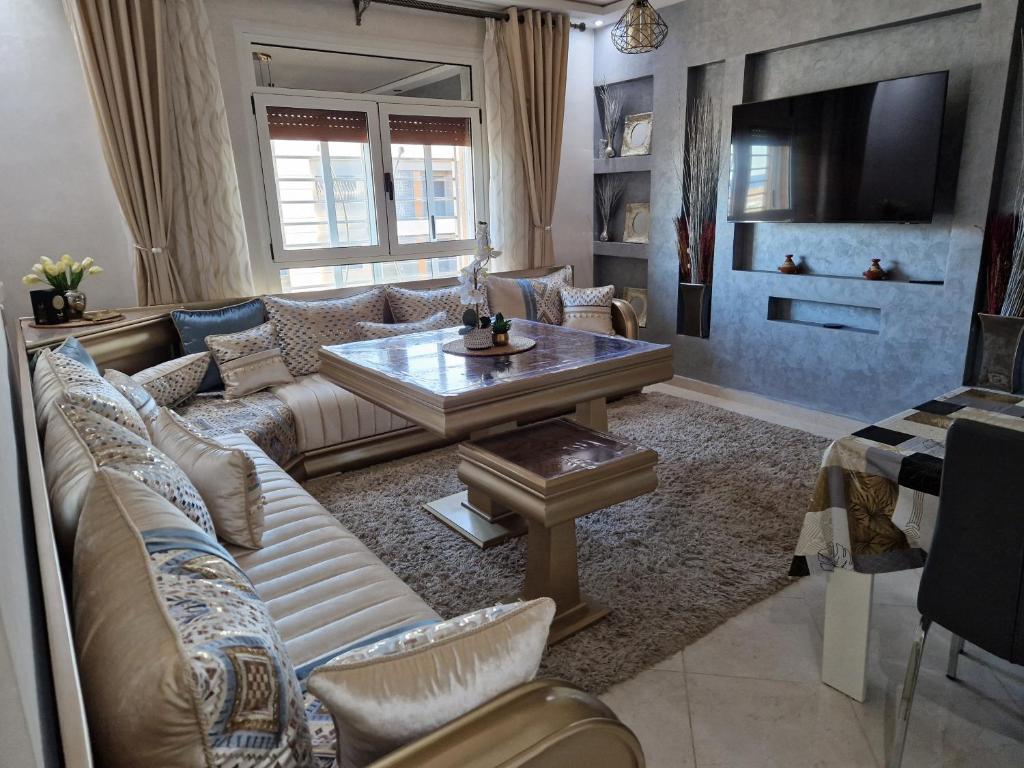 een woonkamer met een bank en een tafel bij Nador Khattabi 2-19 in Nador