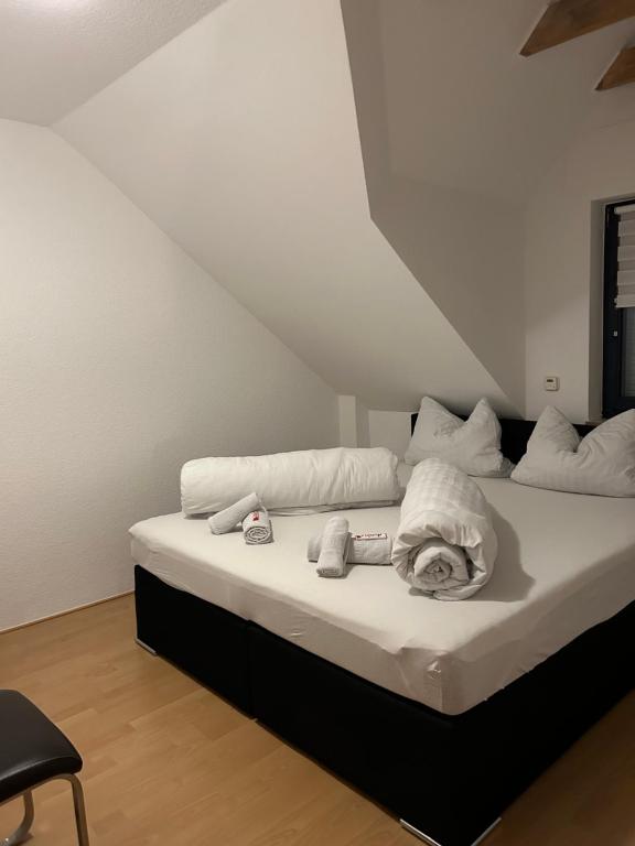 Una cama con sábanas blancas y toallas. en Cute Appartement near Cologne, en Bergisch Gladbach