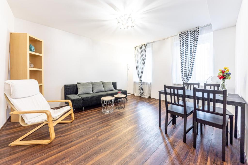 a living room with a couch and a table and chairs at CENTRAL & AFFORDABLE by JR City Apartments in Vienna