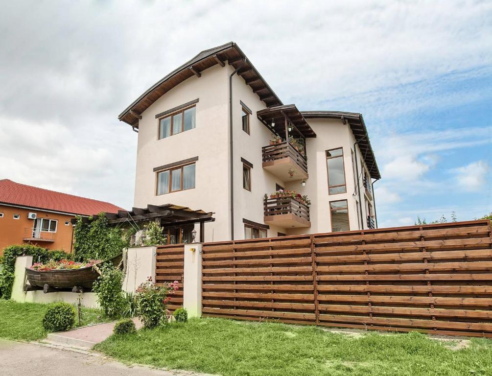 a house with a wooden fence in front of it at Casa Lotca in Costinesti