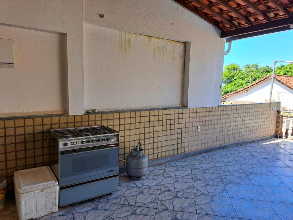 una cucina con piano cottura e una parete piastrellata di Casa Costa Verde-Muriqui a Vila Muriqui