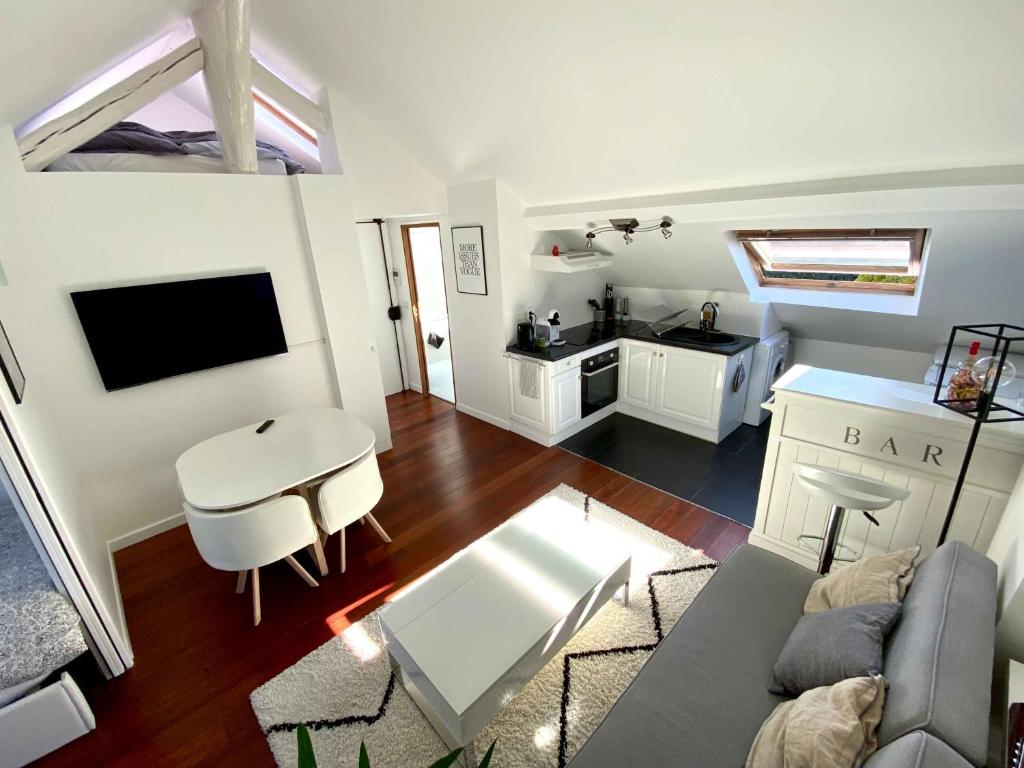 ein Wohnzimmer mit Sofa und Tisch in der Unterkunft Magnifique 2 pièces Theatre de Boulogne in Boulogne-Billancourt