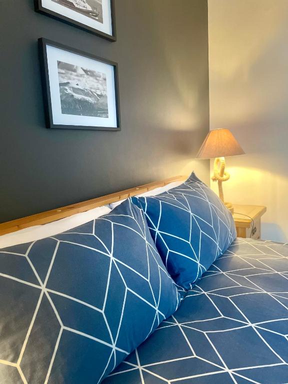 a bed with blue and white pillows in a room at Bungalow33 Benllech in Benllech