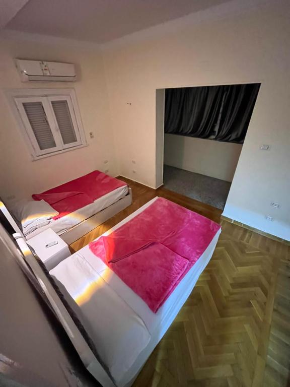 two beds in a room with a window at Cairo de casa hostel in Cairo