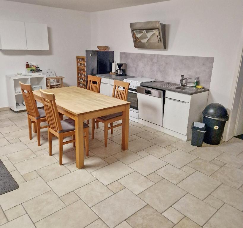 a kitchen with a wooden table and chairs in it at Schönes Apartment / Ferienwohnung am Regen in Blaibach