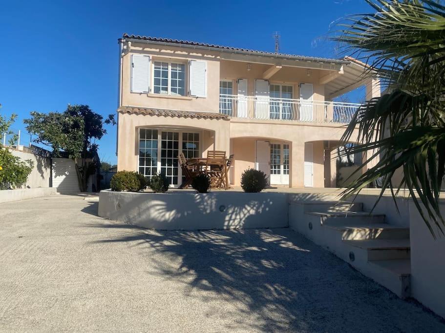 une grande maison avec un palmier en face dans l'établissement La Villa verdoyante, à Baillargues