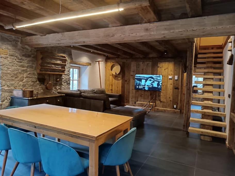 een woonkamer met een houten tafel en blauwe stoelen bij Brand new duplex in the Dolomites - Lupo Bianco in Rocca Pietore