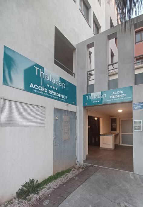 un bâtiment comportant deux panneaux sur son côté dans l'établissement Élégant 30 M2 dans résidence 4 étoiles, au Cap d'Agde