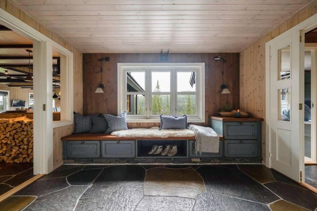 Habitación con banco frente a una ventana en Your Ideal Getaway Awaits in This Charming Cabin Retreat, en Nord Torpa