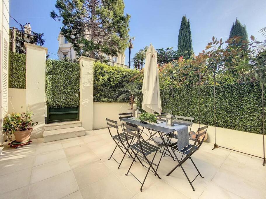 un patio con una mesa con sillas y una sombrilla en 2 Bebrooms Duplex en Cannes