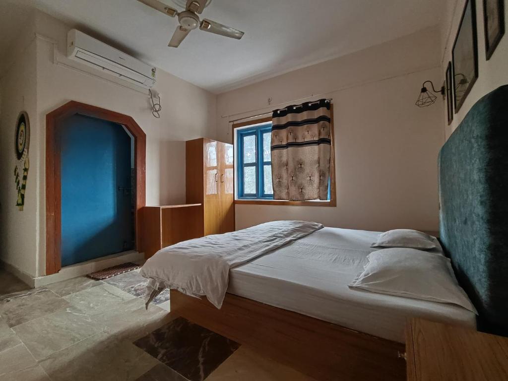 a bedroom with a bed and a window at Nest Tales Backpacker Hostel in Khajurāho
