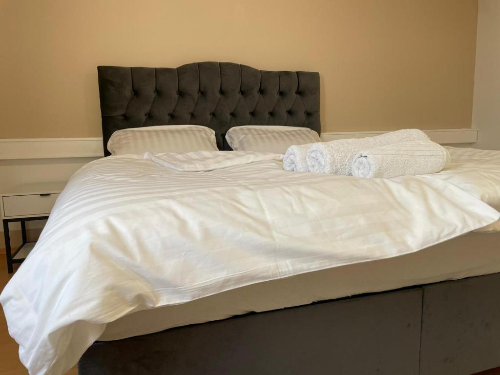 ein großes Bett mit weißer Bettwäsche und Handtüchern darauf in der Unterkunft Deluxe dream home in Linz