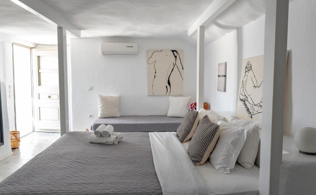 een witte slaapkamer met een bed en een bank bij Anemoi Resort in Naousa