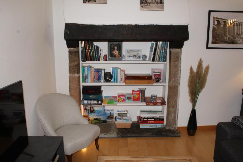 a living room with a book shelf filled with books at Au Pied du Viaduc in Morlaix
