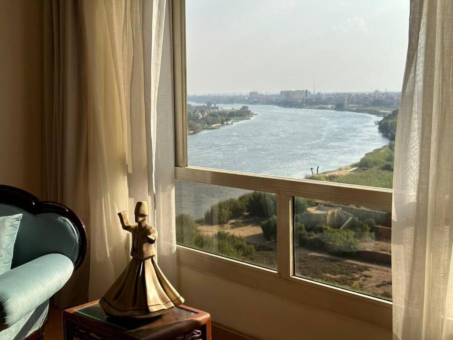 een standbeeld voor een raam met uitzicht op een rivier bij Luxurious apartment for rent with Nile view for families only in Caïro