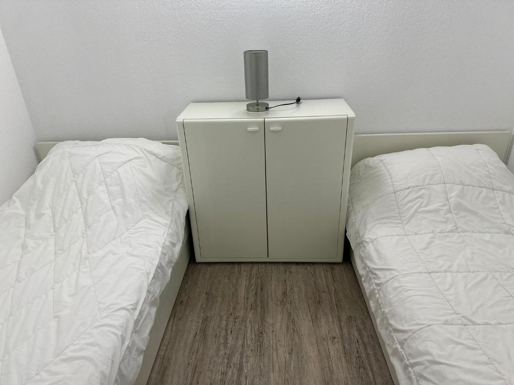 sypialnia z 2 łóżkami i komodą z lampką w obiekcie ButschisBude w mieście Sierksdorf