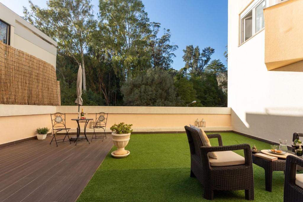 エストリルにあるSeaside Serenity in Estorilのパティオ(芝生、テーブル、椅子付)