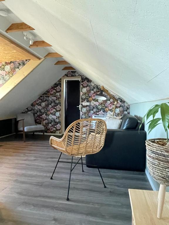 uma sala de estar com um sofá e uma cadeira em Het Zwaluwnest em De Vecht