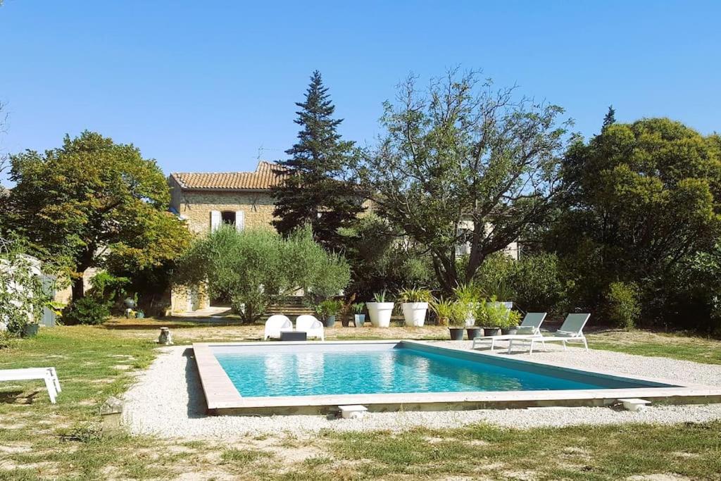 a swimming pool in the yard of a house at Mas de la Sorgue - Rendez-vous en Provence in Bédarrides