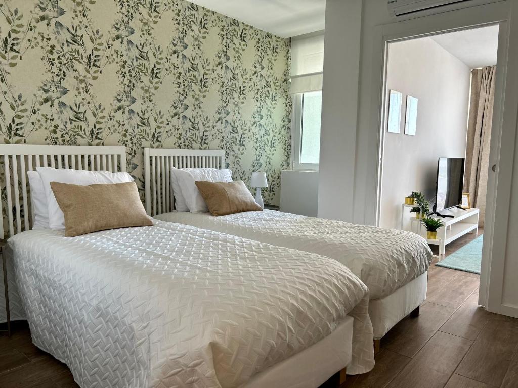 um quarto com uma cama com um edredão branco em Praia da Rocha Torre Verde - Portimao em Portimão