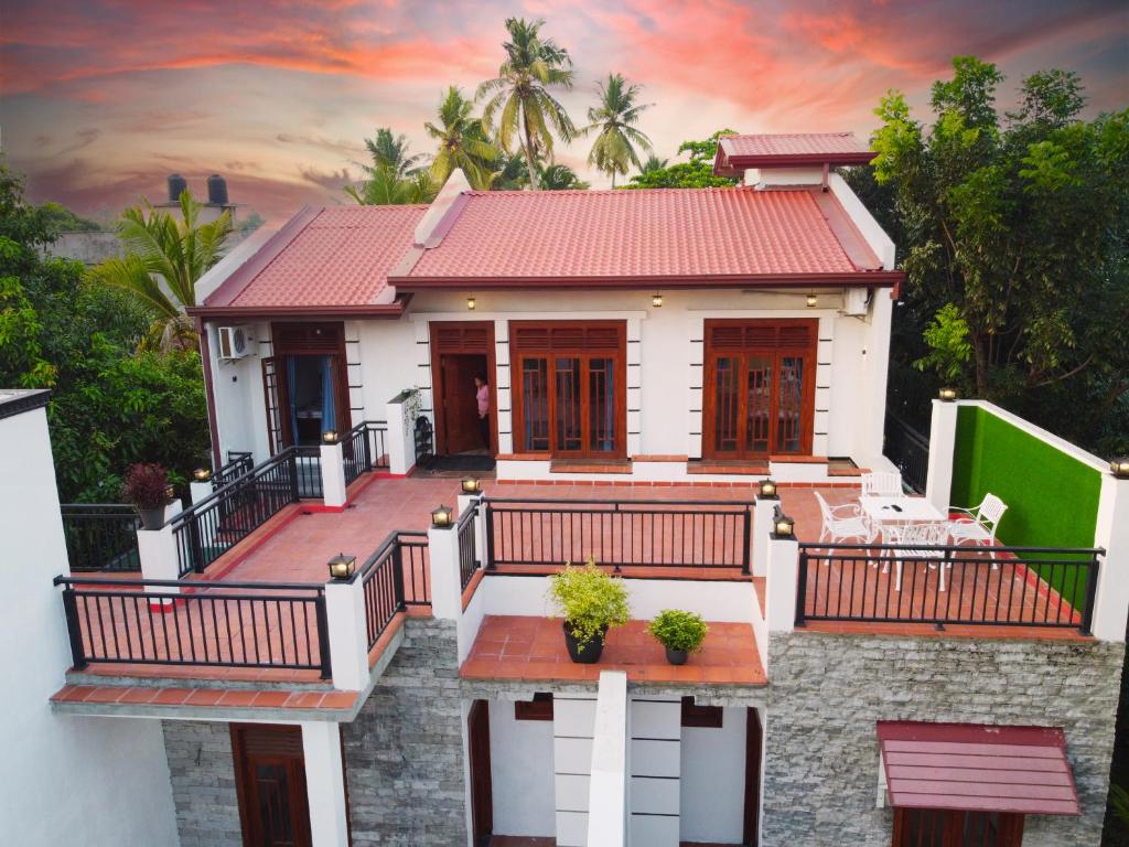 a house with a balcony with a sunset at Sagya Residencies in Panadura