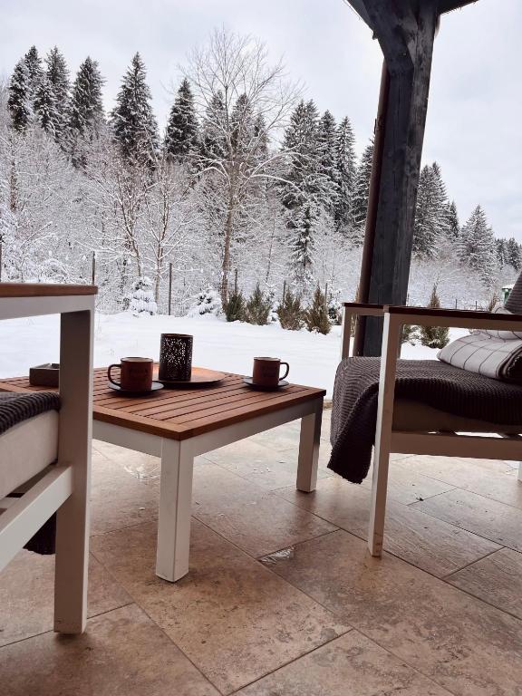 a wooden table with two cups on top of it at Kenzo Chalet in Porumbacu de Sus