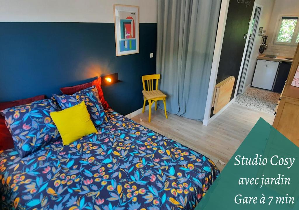 een slaapkamer met een blauw bed en een geel kussen bij Le3BisMyosotis in Massy