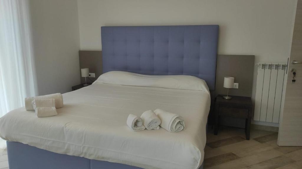 La Perla del Tirreno Guest House في سابري: غرفة نوم عليها سرير وفوط
