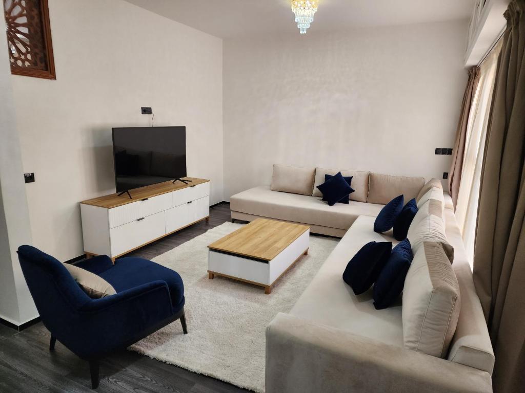 a living room with a couch and a tv at Residence Al Kasbah - VacayX - Chic Triplex 3BR -RABAT in Rabat
