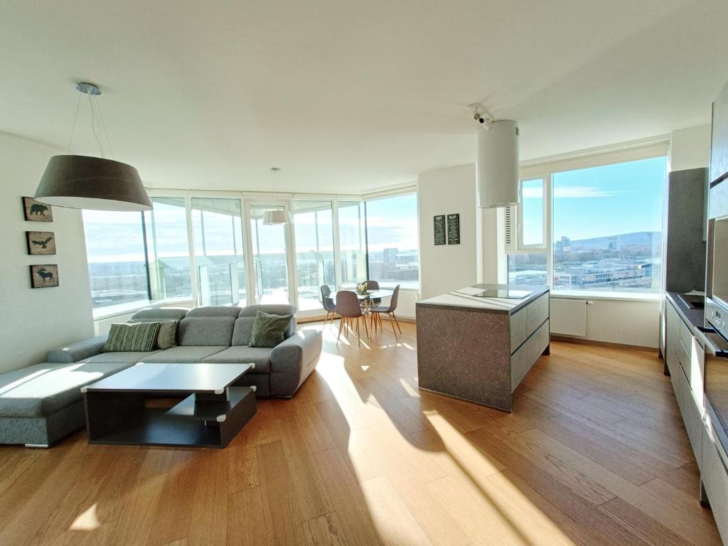 een woonkamer met een bank en een tafel bij Panorama Apartment 3 rooms 19th floor Great view Free parking in Bratislava
