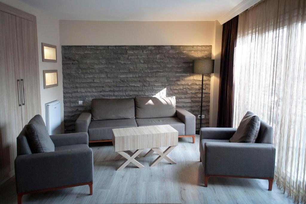 ein Wohnzimmer mit einem Sofa, 2 Stühlen und einem Tisch in der Unterkunft Sun Suites in Istanbul