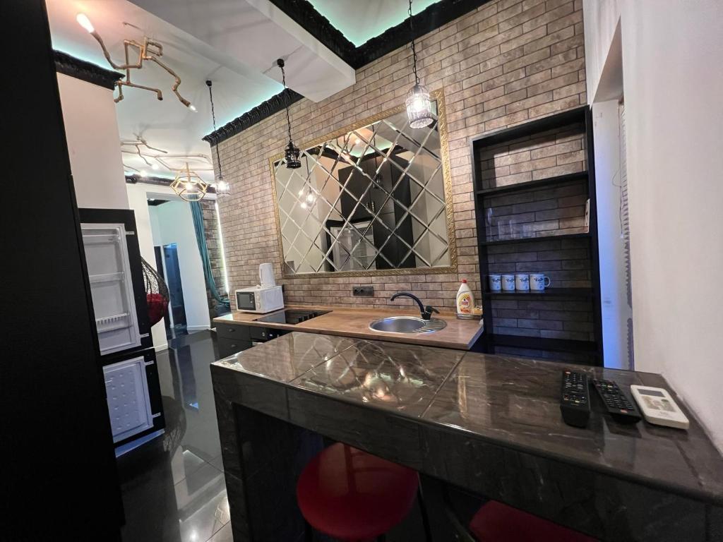 a bathroom with a sink and a brick wall at Center Apartment in Chişinău
