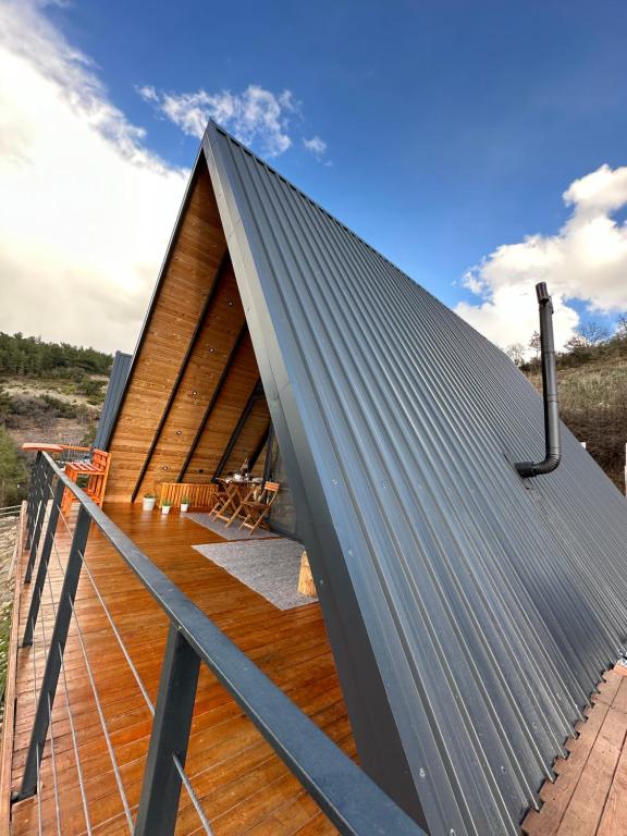 un techo de metal en una casa con una terraza de madera en Tlos Nature Houses, en Yaka