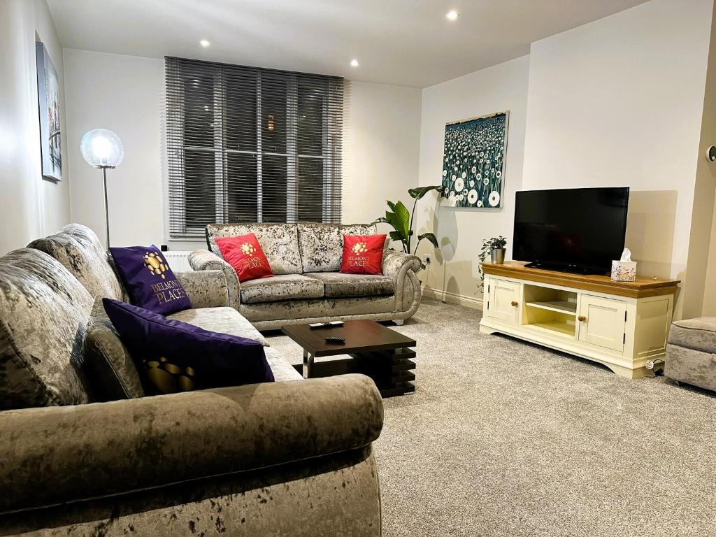 a living room with two couches and a flat screen tv at Hudson Apartment - 2 bedroom, Oakham Centre by Belmont Places in Oakham