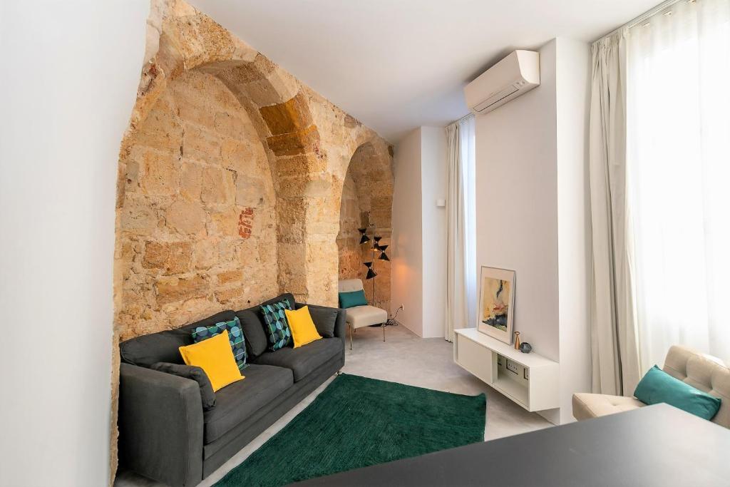 - un salon avec un canapé et un mur en briques dans l'établissement Be Local - Historic house of Santo André in Alfama - Lisbon, à Lisbonne