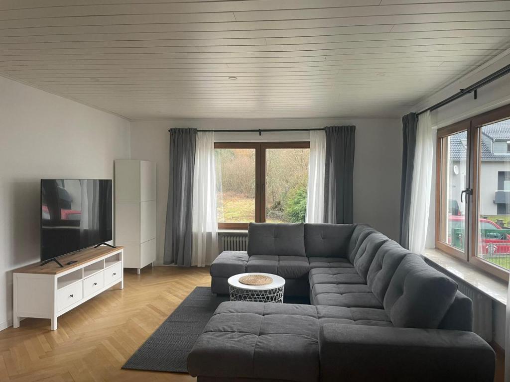 a living room with a couch and a television at Ferienwohnung Am Schillerfelsen Dahn in Dahn