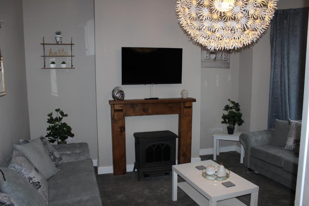 a living room with a fireplace and a flat screen tv at Ashville Grange in Scarborough