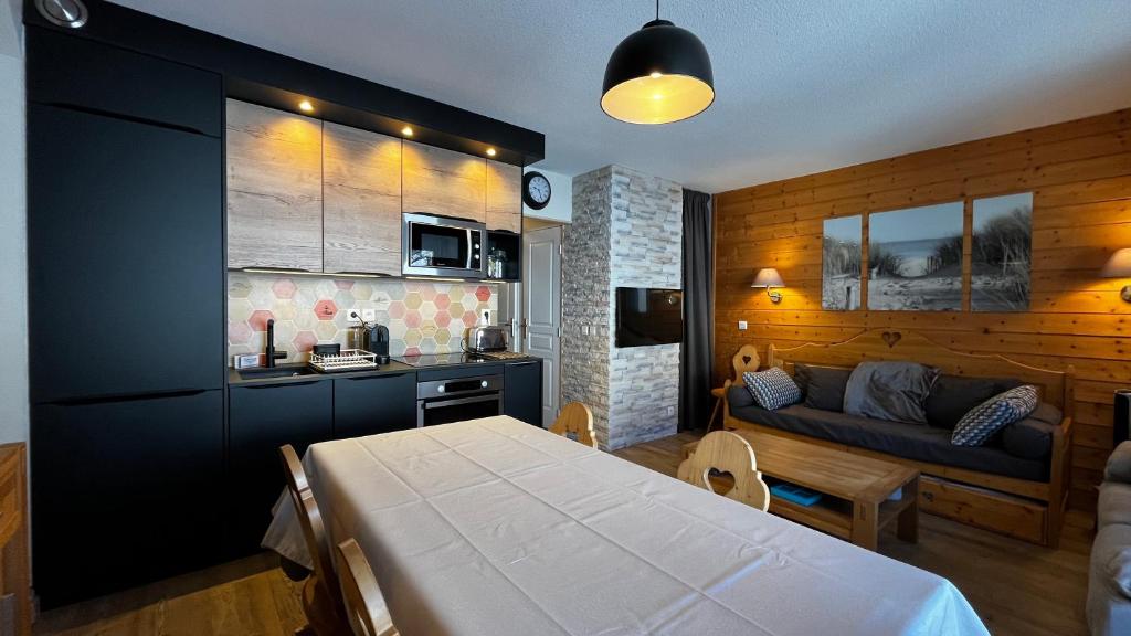 Il comprend une cuisine et un salon avec un lit et un canapé. dans l'établissement Duplex 60m² - Les Balcons de Sirius - Risoul, à Risoul