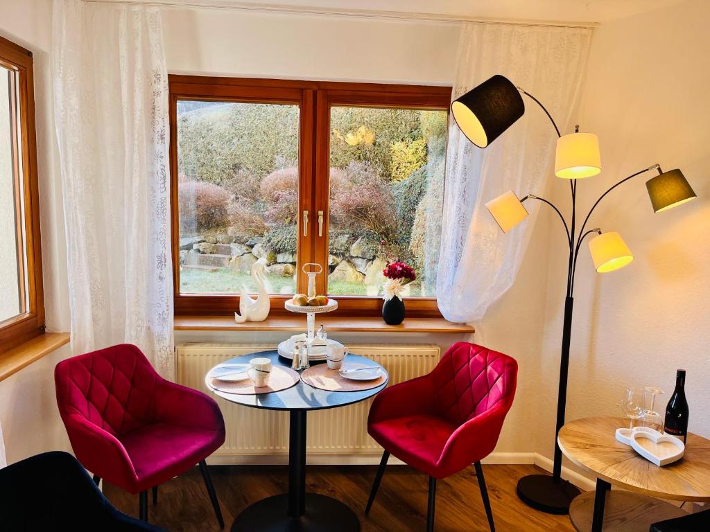 Zimmer mit einem Tisch, 2 Stühlen und einem Fenster in der Unterkunft Boutique Apartment in Lenzkirch