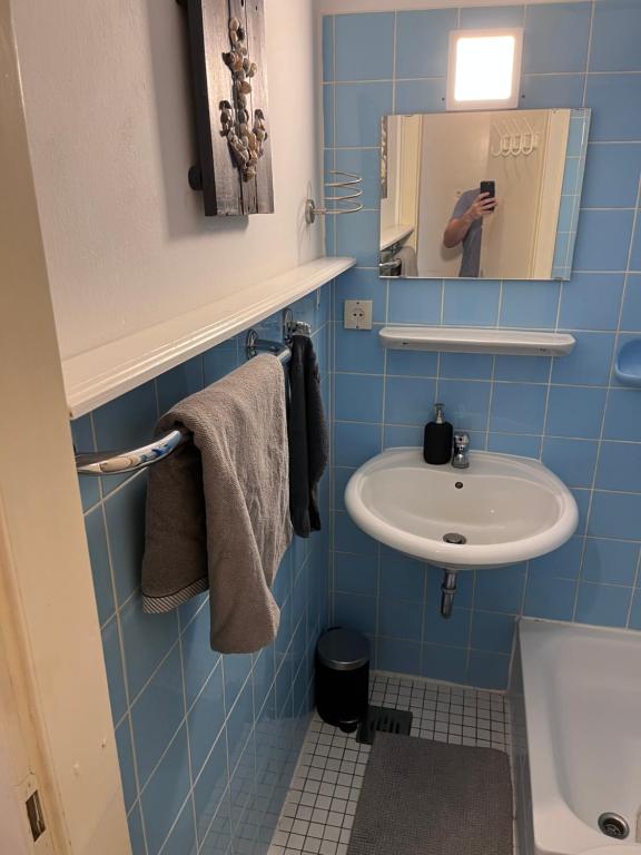a person taking a picture of a bathroom with a sink at Wohnung mit Blick über Itzehoe in Itzehoe