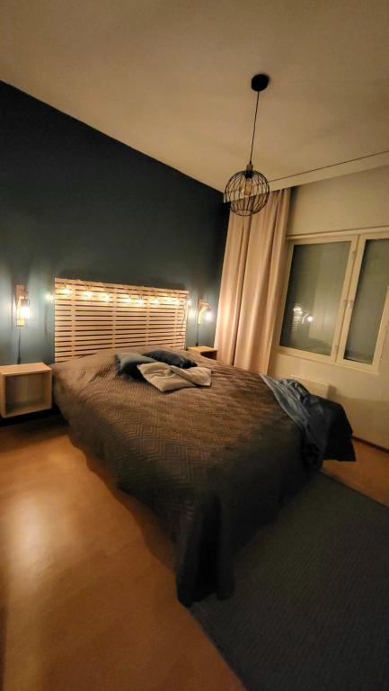 a bedroom with a large bed with a window at Tyylikäs loma-asunto Alppitalossa in Tahkovuori