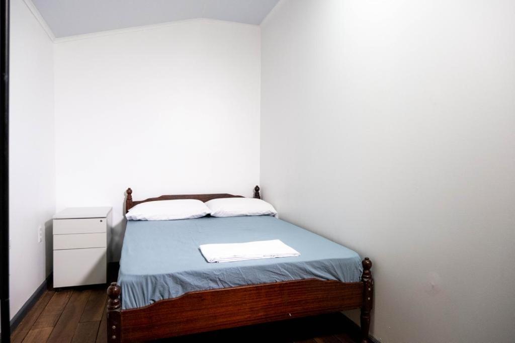 1 dormitorio pequeño con 1 cama en una habitación blanca en Rena’s Appartement, en Paramaribo