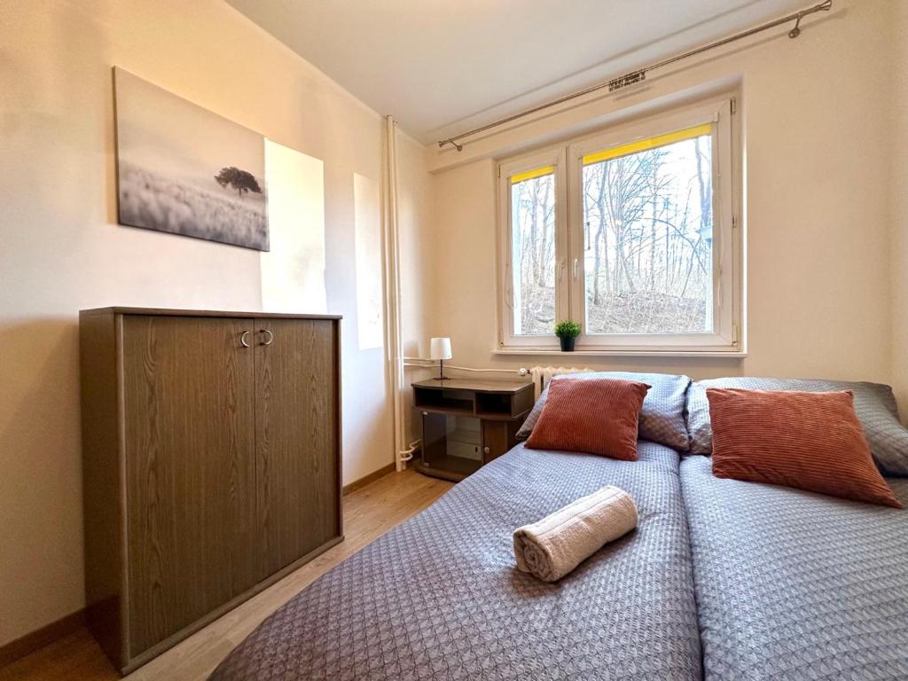 a bedroom with a bed and a desk and a window at MMRent Przytulny apartament w Sopocie in Sopot
