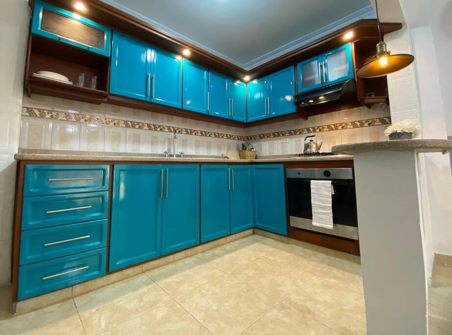 uma cozinha com armários azuis e piso em azulejo em Apartamento con garaje, sin escaleras y muy bien ubicado em Palmira