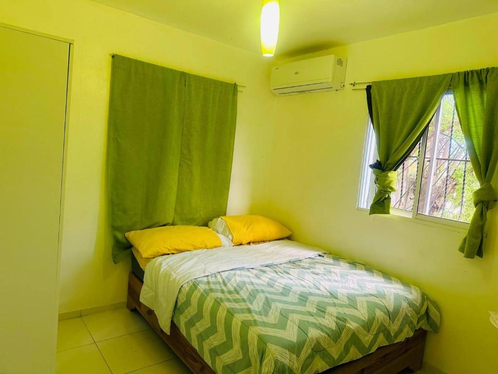a small bedroom with a bed and a window at Casa Vasquez in San Felipe de Puerto Plata