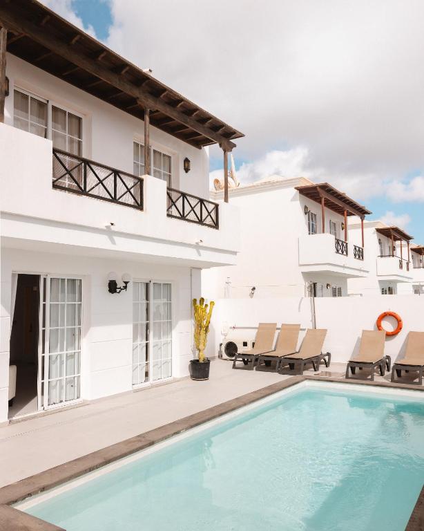 a villa with a swimming pool in front of a house at Villa Fariones in Tías