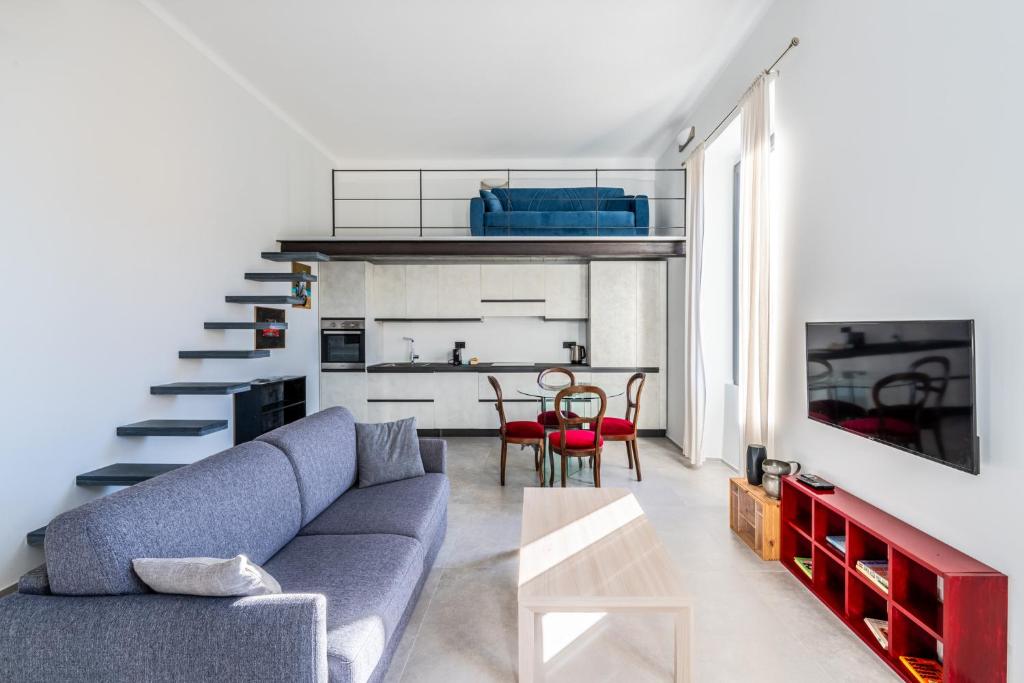 un soggiorno con divano blu e scala di Boccadasse Chic Urban Retreat a Genova