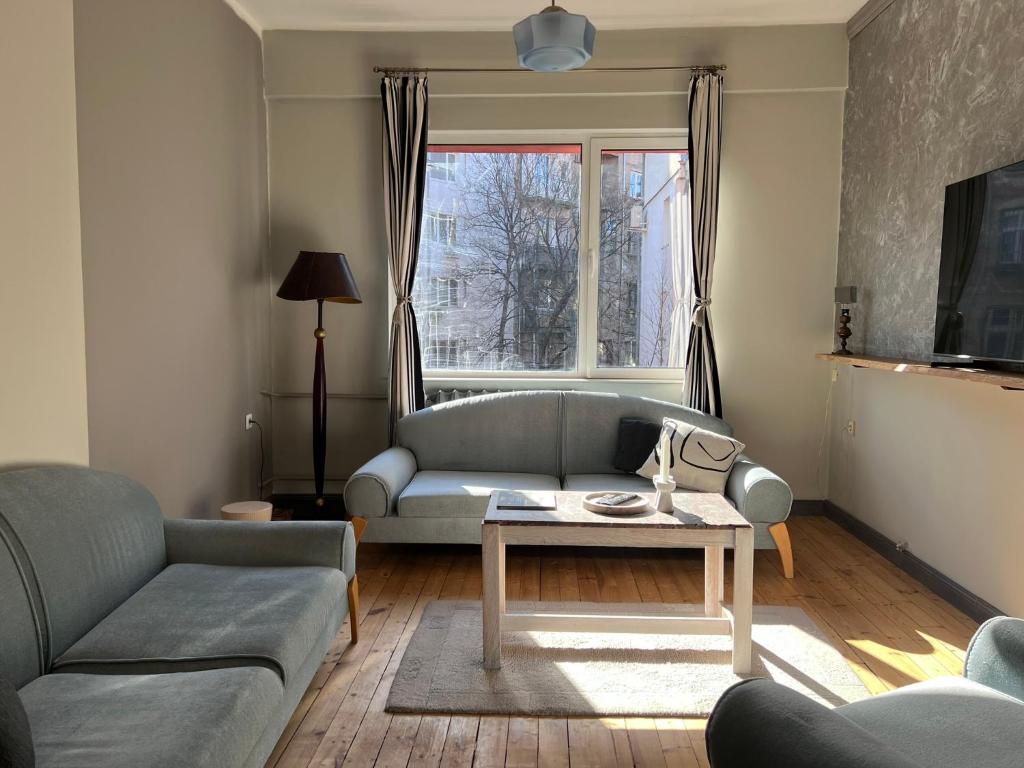 a living room with a couch and a table at Eternity Apartment: Award-Winning Design in the Heart of the City Center in Sofia