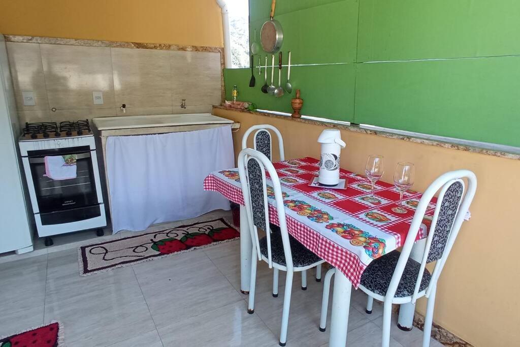 a kitchen with a table and chairs with a table and a table and a stove at Centro da cidade, ótimo lugar in Caparaó Velho