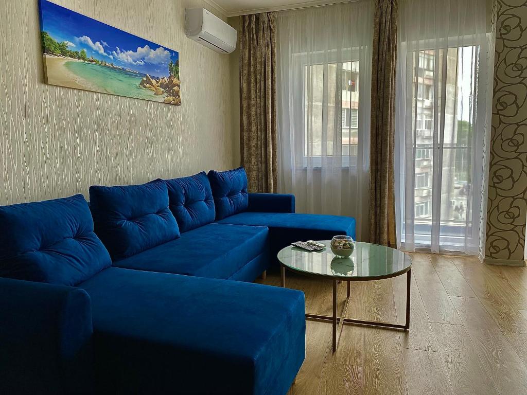 a living room with a blue couch and a table at AVRORA in Varna City